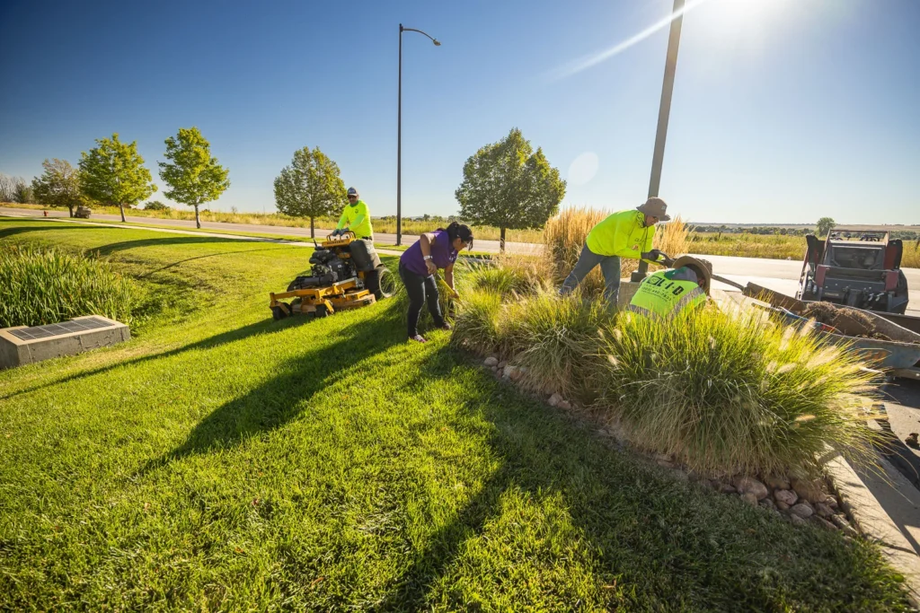 commercial property landscape maintenance crew planting and mowing